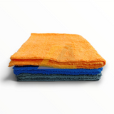 A stack of folded microfiber cloths in orange, blue, and dark gray, photographed on a clean white background.