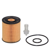 A cylindrical automotive oil filter with a pleated beige filter media and a black top cap, shown alongside a small clear plastic connector and two black O-rings on a plain white background.