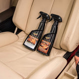 Two bottles of car interior cleaner on a beige car seat.