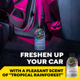Bottle of Meguiar's air freshener with text promoting a tropical rainforest scent in a car interior.
