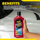 A hand holds a bottle of Meguiar's Water Spot Remover in front of a white car, with a yellow and black graphic overlay detailing the product's benefits.