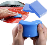 Blue car cleaning sponge with a hand holding it and another hand using it on a red car surface.